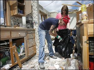 Kristen Sheehy, left, and her mother, Darlene Sheehy, work in the wrecked Millbury home where Darlene waited out the storm.
