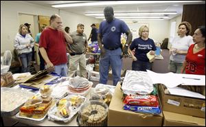 Nate Towns, center in blue, an off-duty trooper with the State Highway Patrol post in Bowling Green, coordinates food donations at Mainstreet Church.