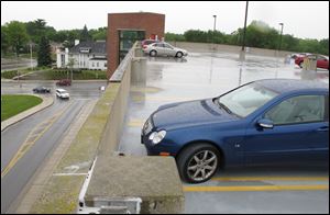 Larry Kaczala's Mercedes-Benz compact coupe, foreground, sits apart from the rows of other parked vehicles on the open-air parking deck at Toledo Hospital.