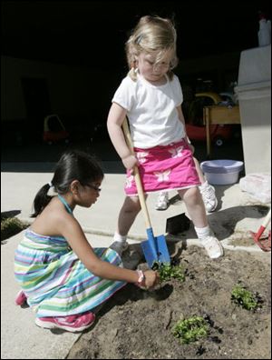 Sonia Mistry, 5, left, and Margaux Guerin, 4, do some planting.