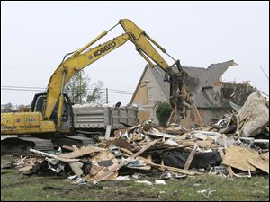 Debris from the weekend tornado is removed on Main Street in Millbury, where plans are moving ahead on many fronts in the midst of the tremendous devastation in Lake Township.