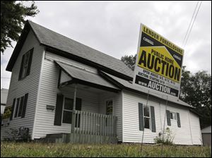 The sign in front of this home in Owosso, Mich., is emblematic of the nation's foreclosure woes.