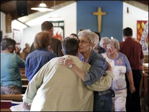 Marilyn Roth, left, and Grace Bookenberger, hug at a community prayer service at Calvary Lutheran Church on Bradner Road in Lake Township. The  service was yesterday.
<br>
<img src=http://www.toledoblade.com/graphics/icons/photo.gif> <font color=red><b>VIEW</b></font>: <a href=