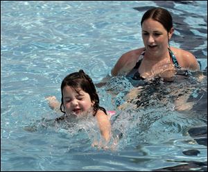 Katie Bertsch of Toledo teaches her daughter, Addison, 4, how to swim at the Rolf Park pool in Maumee.