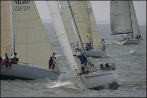 Two boats attempt to avoid a collision as they tack for position at the start of the race near the Toledo Harbor Lighthouse. 