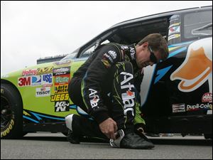 Carl Edwards slips on his racing shoes before the start of the race. It was another day without a win for Edwards and his Ford teammates.