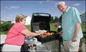 Joanne and Ron Glick cook steaks, kabobs and vidalia onions on the grill.