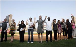 Fourteen people who came to the United States from other countries took the oath of citizenship Monday at a Mud Hens game.