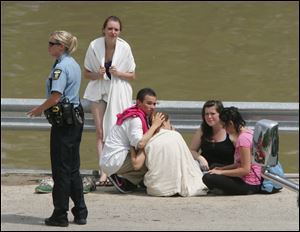 A police officer stands by as friends of Craig A. Seymour await word during the rescue effort.