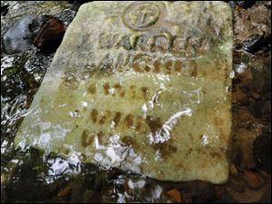 Some of the headstones are worn and faded, but others found in the muck near the stream bed offer some identifying clues.