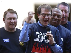 Bob King, center, leads about 1,100 delegates at a Detroit rally after he was sworn in as UAW president. Teamsters chief James P. Hoffa is at left.