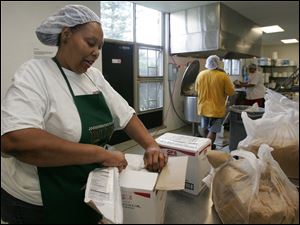 Viveca Crews, Mr. Baker's
sister, prepares brown sugar
for the sauce. 
