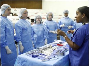 Tracie Braylock, a registered nurse shows high school students from throughout northwest Ohio some of the tools used in the operating room at the University of Toledo Medical Center, formerly the Medical College of Ohio. 
