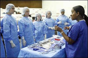 Tracie Braylock, a registered nurse shows high school students from throughout northwest Ohio some of the tools used in the operating room at the University of Toledo Medical Center, formerly the Medical College of Ohio. 