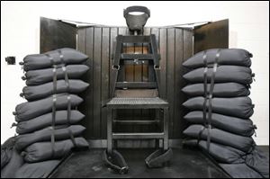 The execution chamber at the Utah State Prison after Ronnie Lee Gardner was executed by firing squad. The bullet holes are visible in the wood panel behind the chair. 