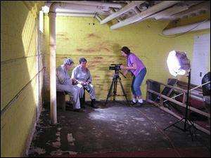 Lynn King films Sister Margaret Hall, left, and sister Nancy Ferguson as they eat a prison meal of oatmeal during a scene from 'Interrupted Lives' in the basement of Toledo St. Agnes Convent.
