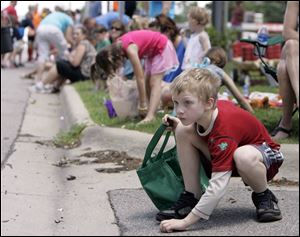 Joshua Fellman, 9, of Lambertville, bends to retrieve some of the candy distributed during the parade.