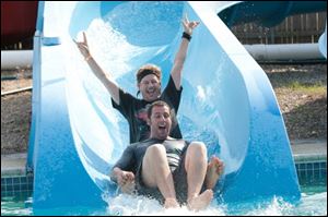 Adam Sandler, foreground, and David Spade barrel down a water slide in a scene from 'Grown Ups.'