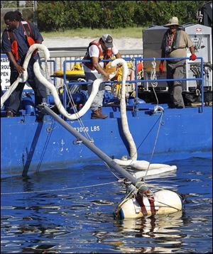Workers place oil-containment booms into the water in the Perdido Pass in Orange Beach, Ala., where oil from the Deepwater Horizon continues to wash ashore. Estimates of BP's eventual costs of the spill range up to $60 billion, including penalties, damages, and cleanup costs.
