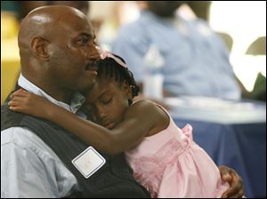 Keynote speaker Mark Robinson, from Northcoast Fatherhood Collaborative and Lourdes College, has a safe place for daughter Moriah Robinson, 6, to sleep.