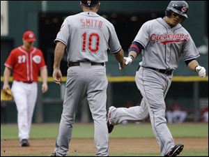 The Indians' Shin-Soo Choo is congratulated by third base coach Steve Smith after hitting his first of two home runs.