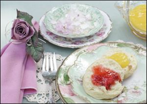 Florence Oberle's scones with strawberry jam, left, and lemon curd. In the background, rose petals float in a finger bowl.