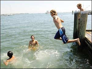 A group of boys finds respite in the Mystic River, in eastern Connecticut. Beaches across the region were jammed Monday as temperatures neared dangerous levels.