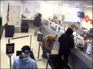 A bank surveillance photo shows the five armed robbers in the KeyBank branch at 5756 West Central Ave.