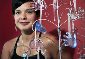 Rachel Nixon displays some of the 3-D glass keepsakes she and husband Daniel produce.