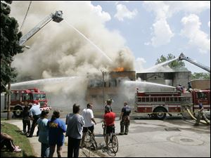Toledo firefighters battle a blaze suspected to be arson at the former Tate Funeral Service on Broadway. 