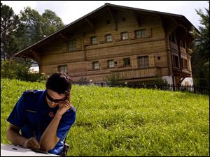 A police officer takes notes outside Roman Polanski's chalet in Gstaad, Canton of Berne, Switzerland. and his family reportedly left the country yesterday.