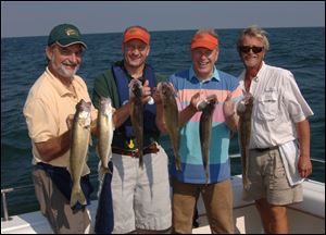 Blade outdoors editor Steve Pollock, from left, ODNR director Sean Logan, Gov. Ted Strickland and charter captain Paul Pacholski show off their day's catch.