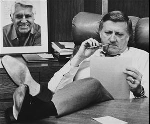 This Oct. 21, 1981, file photo shows New York Yankees owner George Steinbrenner working at his desk at Yankee Stadium in New York, before Game 2 of the World Series. On the wall behind Steinbrenner is an autographed photo of Cary Grant. 