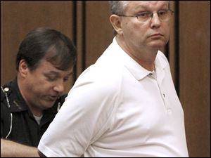 Dan Burns is handcuffed after receiving his sentence for racketeering, theft in office, and tampering with records.