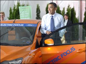 As Michigan Gov. Jennifer Granholm, left, looks on, President Obama enters a
battery-powered Ford Focus on display during his stop in Holland, Mich.