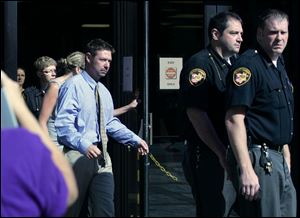 Eric Skowron is escorted out of Toledo Municipal Court by deputy sheriff personnel after his arraignment for shooting Tyson.
