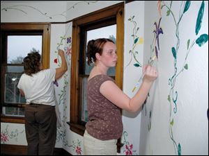A Lourdes College art student paints a mural in the Padua House during the College‘s Week of Service.

