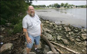 Gene Kidd of the group Visions for Point Place stands on a causeway that links the park to Grassy Island.