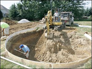 A crew from Hawaiian Pool Builders in Maumee works on a residential pool in Maumee. Company president Mike Kerr says residential pool sales are up 50 percent overall from last year. 