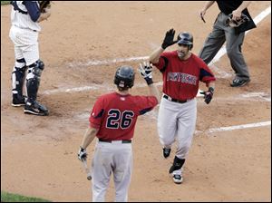 Pawtucket's Mike Lowell is greeted by Lars Anderson at home plate after hitting one of his three home runs at Fifth Third Field, a record for a visiting player, as Hens catcher Max St-Pierre watches. 