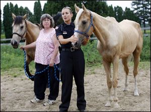 Erin McKibben, cruelty investigator for the Wood County Humane Society, right, shows three of the malnourished horses that were ceased and taken to a foster home in Pemberville. Janice Wilcox, left, is taking care of the animals at her home. 