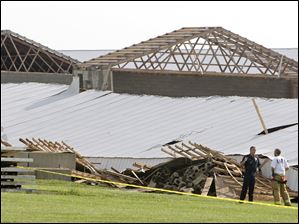 Firefighters survey the scene of a buliding collapse at Ohio Fresh Eggs in central Ohio, where two people were killed Wednesday.