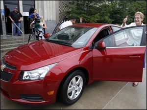 

Congressman Marcy Kaptur gives a thumbs-up after arriving at GM Toledo Powertrain in a red, four-door Chevy Cruze that she drove from the nearby Miracle Mile Shopping Center. 