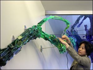 Artist Sayaka Ganz works on the 58-foot long sculpture 'RE-surgence,' in the Huntington Center.