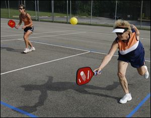 Judy Bastian, front, and Paige Armstrong are among a growing group gathering in Rossford to play Pickleball.