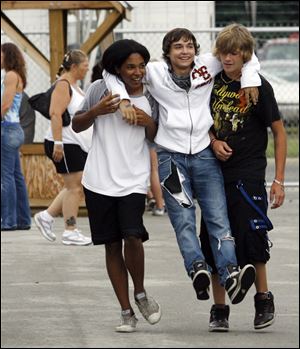 Chris Schermerhorn, from left, Chase Nickels, and Kyle Cornell, all 15, get a laugh out of their version of strolling down the midway at the Wood County Fair in Bowling Green as they check out the sights.