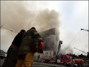 Firefighters respond to a blaze at a two-story building that partially collapsed on Friday in Detroit.
