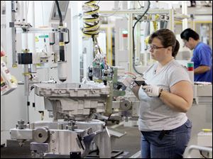 Quality inspector Rhonda Modrzynski prepares a transmission case for assembly at GM's Toledo Powertrain, where improvements in ergonomics have decreased injuries and further increased efficiency at a factory consistently honored for its productivity. 