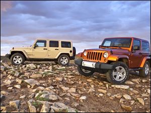 The 2011 Jeep Wrangler Unlimited Sahara, at left, and the Wrangler Sahara.
