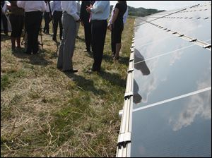 Ralph Izzo, left, chairman, chief executive, and president of Public Service Enterprise Group of Newark, N.J., chats with Ohio Gov. Ted Strickland next to the solar panels during the news conference. The solar farm is owned by a subsidiary of Public Services.